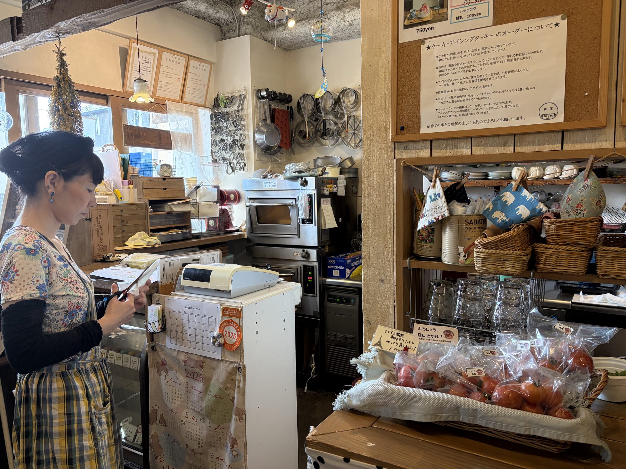 チマカフェの店主と店内に並べられた、てるてる農園の野菜